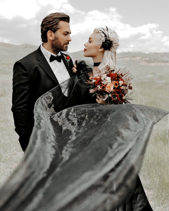 Services-01 Outdoor wedding photo of a couple in elegant attire with a black gown and bouquet.